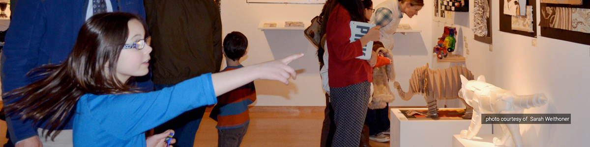 A reception guest explores the 2014 Youth Art Month exhibit (photo courtesy of Sarah Weithoner)
