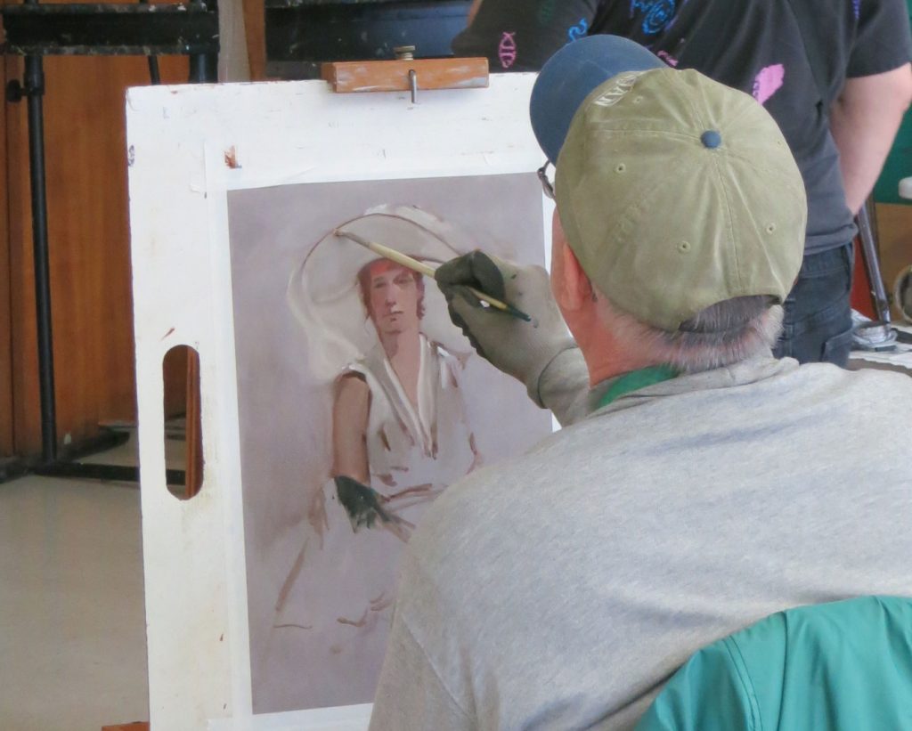 An artist works on a painting during a portrait drop-in session (HCAC photo)
