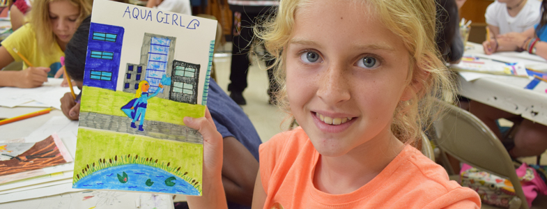 A summer camper displays their finished artwork (HCAC photo)