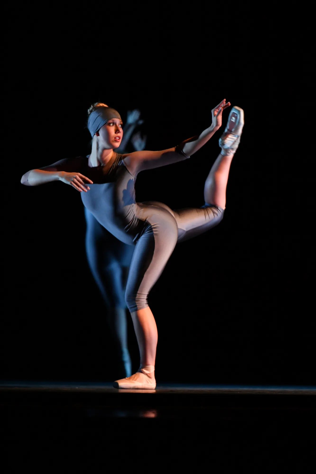Dancer posing with on stage against black background