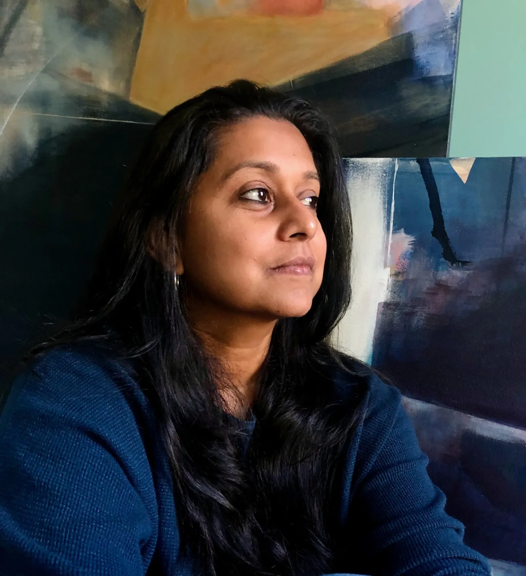 Woman with dark black hair looks toward the side.