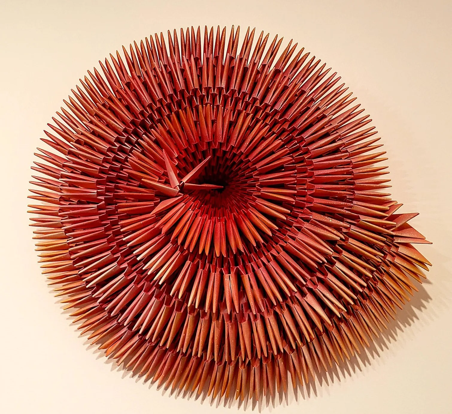 Intricately placed, folded red ombre paper spirals outwards.