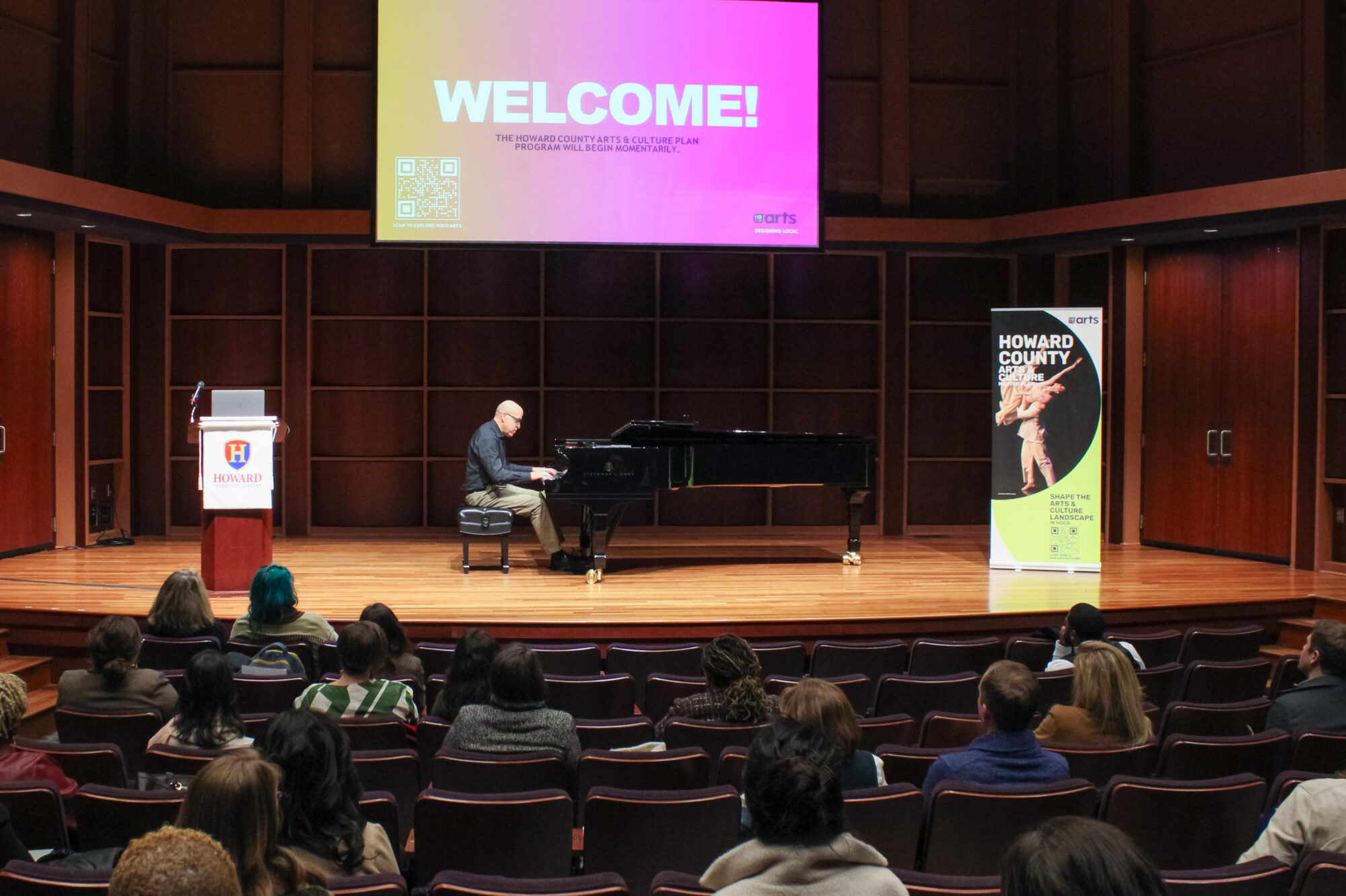 Man plays grand piano on stage