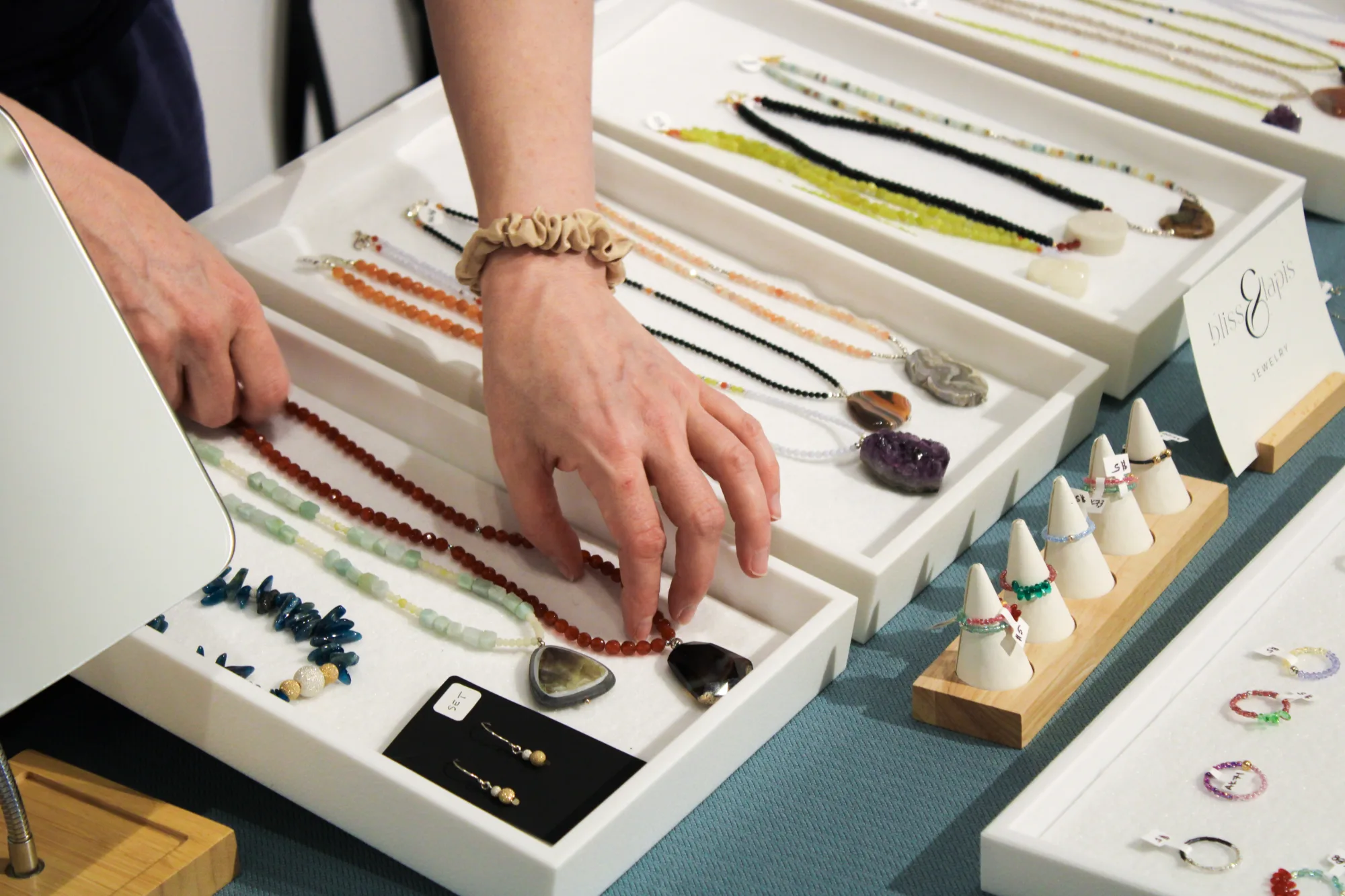 Hands organizing jewelry on a table