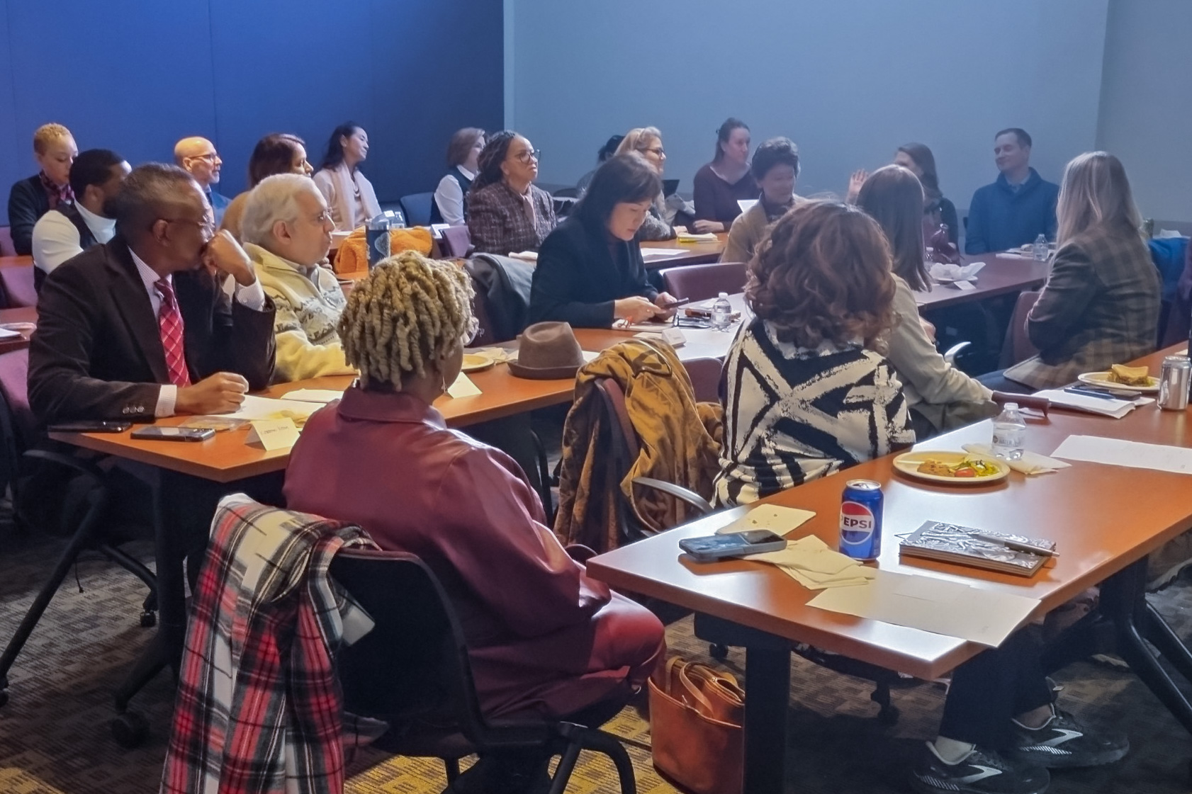 Large group of people seated in classroom talking