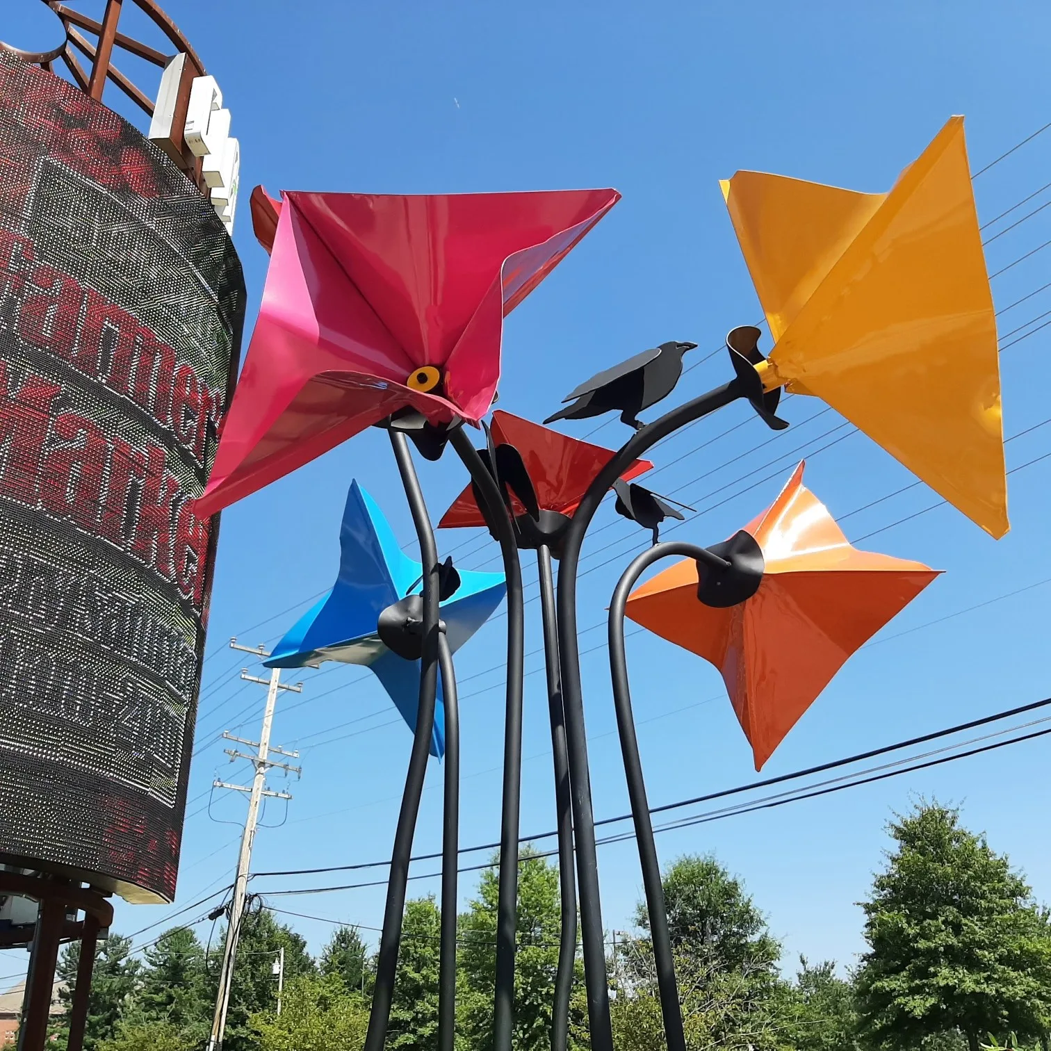Five large, sculpted colorful metal flowers