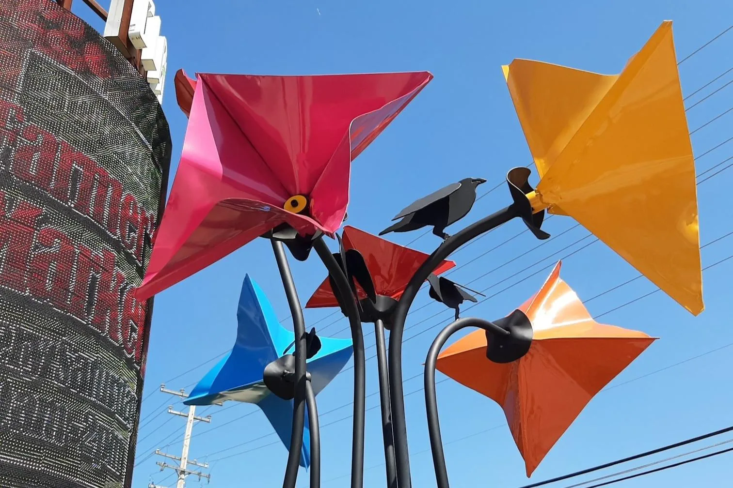 Five large, sculpted colorful metal flowers