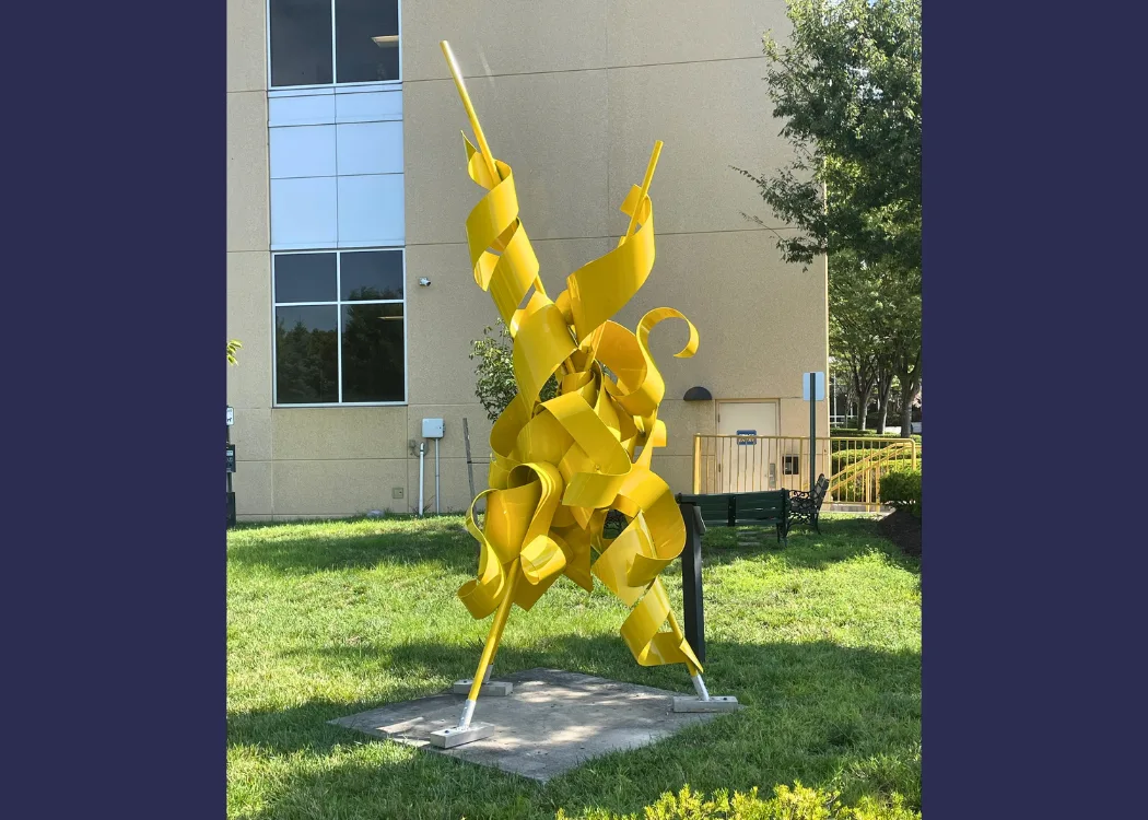 large yellow sculpture in front of a building