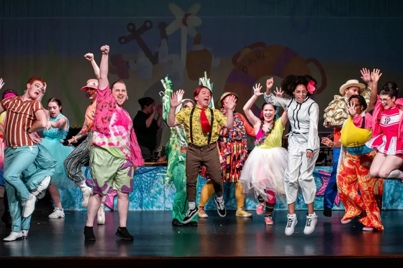performers wearing brightly colored clothing on a stage