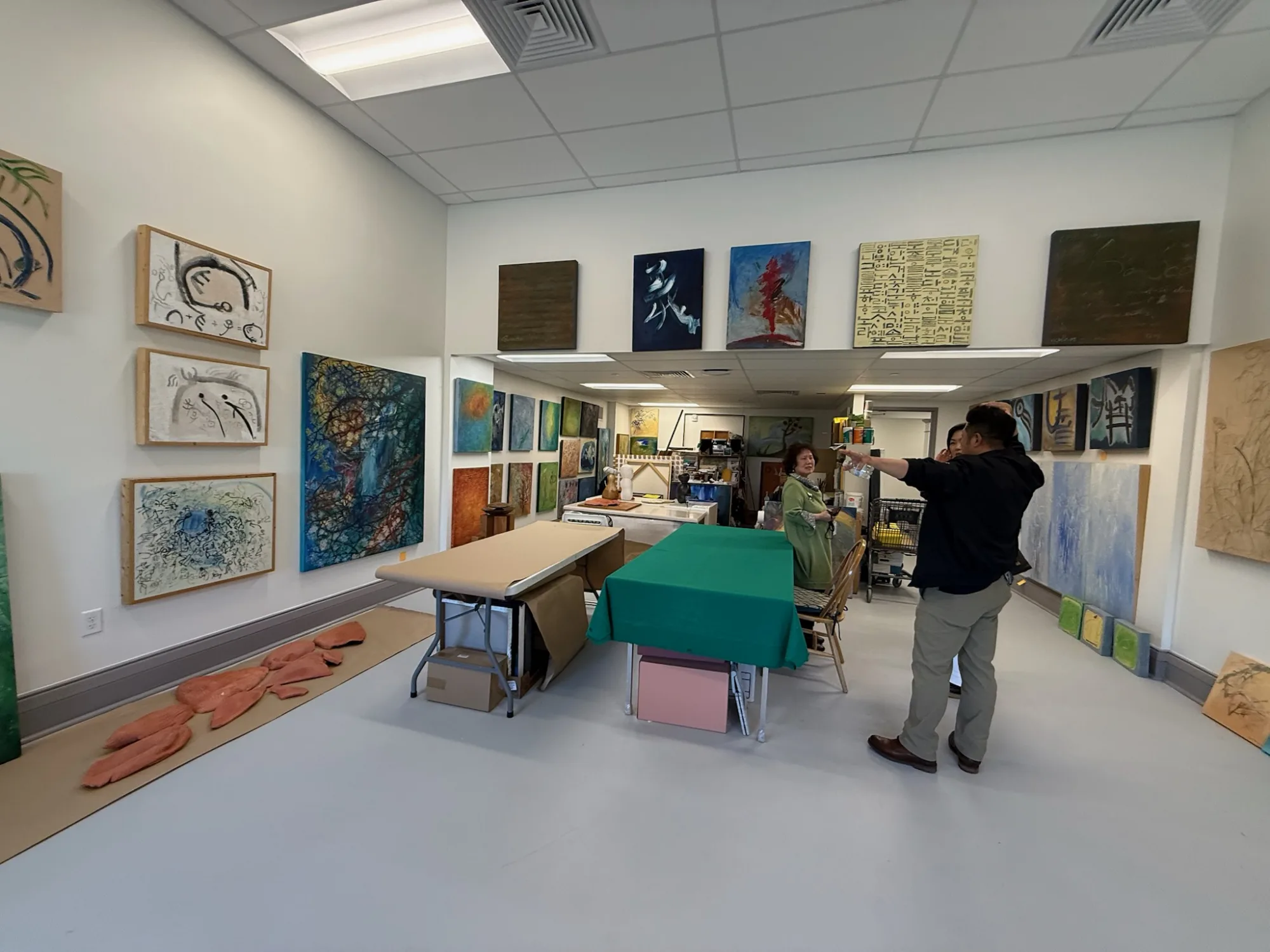 white walls with art work and people talking