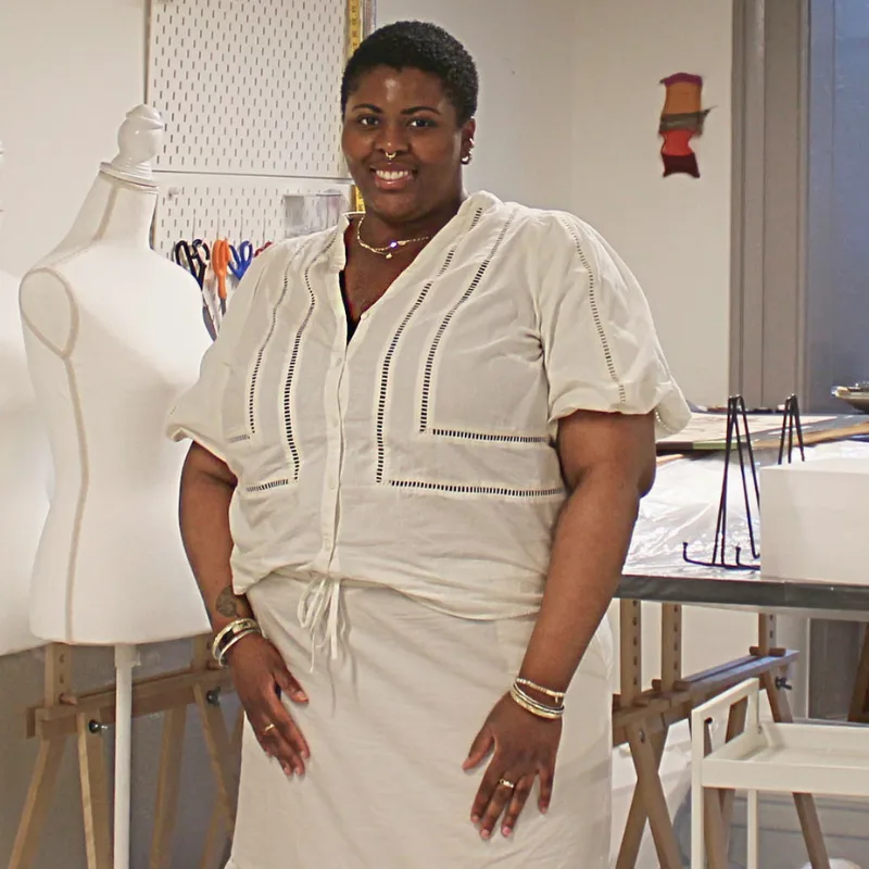 woman in room with dress form and white background